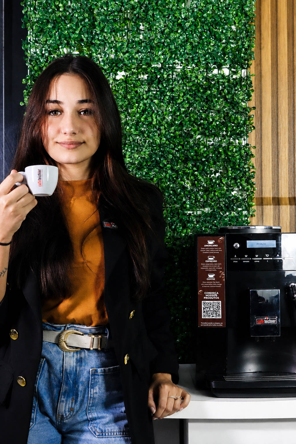 Consultora Caffè Teichner sorrindo ao lado da máquina, pronta para orientar a instalação na sua empresa